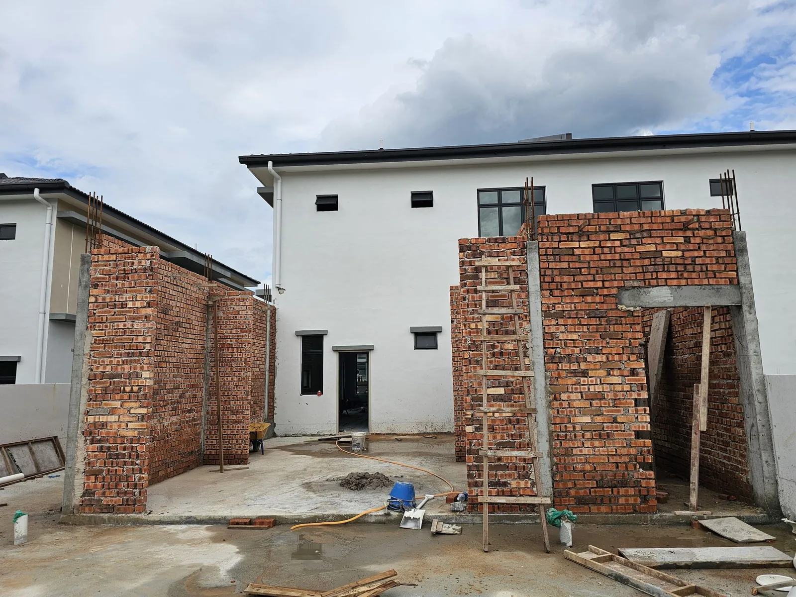 Jasin Parkland extension brick walls rising on the slab behind the house