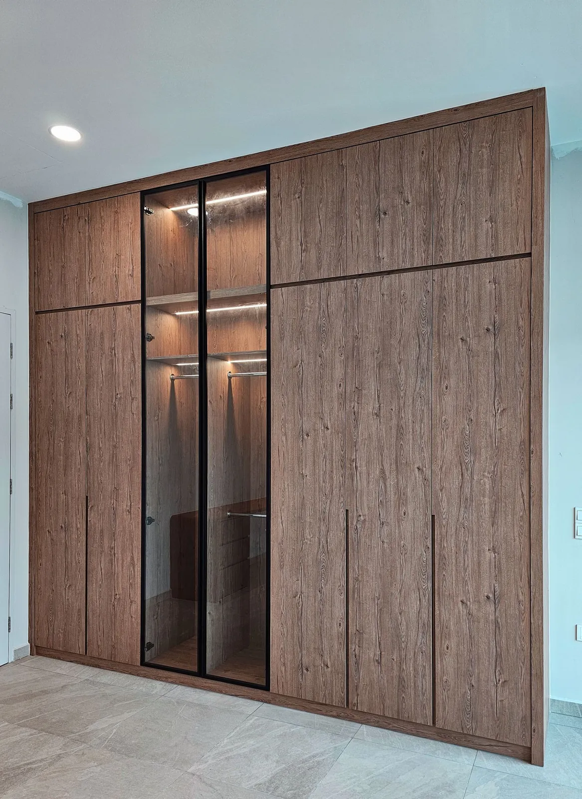 Molek Residence 落地木纹衣橱，中间是灯光玻璃门