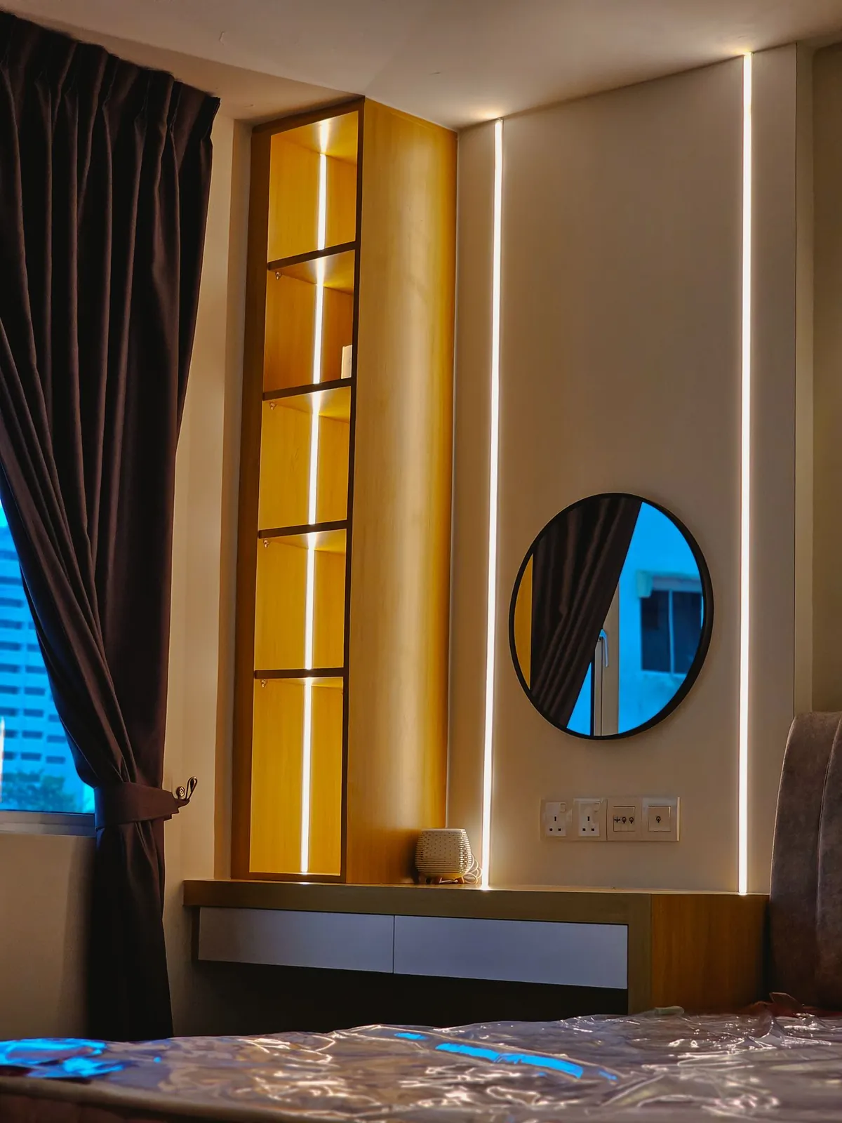 Taman Kesidang bedroom with lit vertical display shelf and round mirror