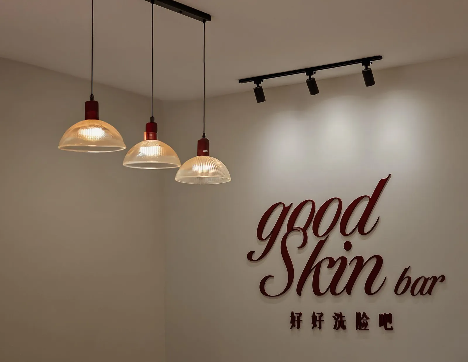 Good Skin Bar wall logo with ribbed-glass pendants and track lights