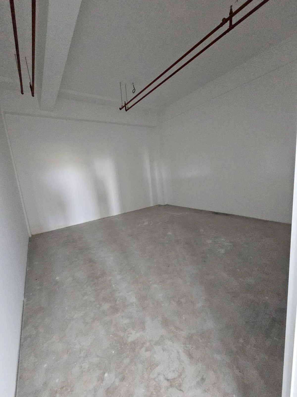 Ee Pilate Studio 装修前的白色空房间与红色天花管道