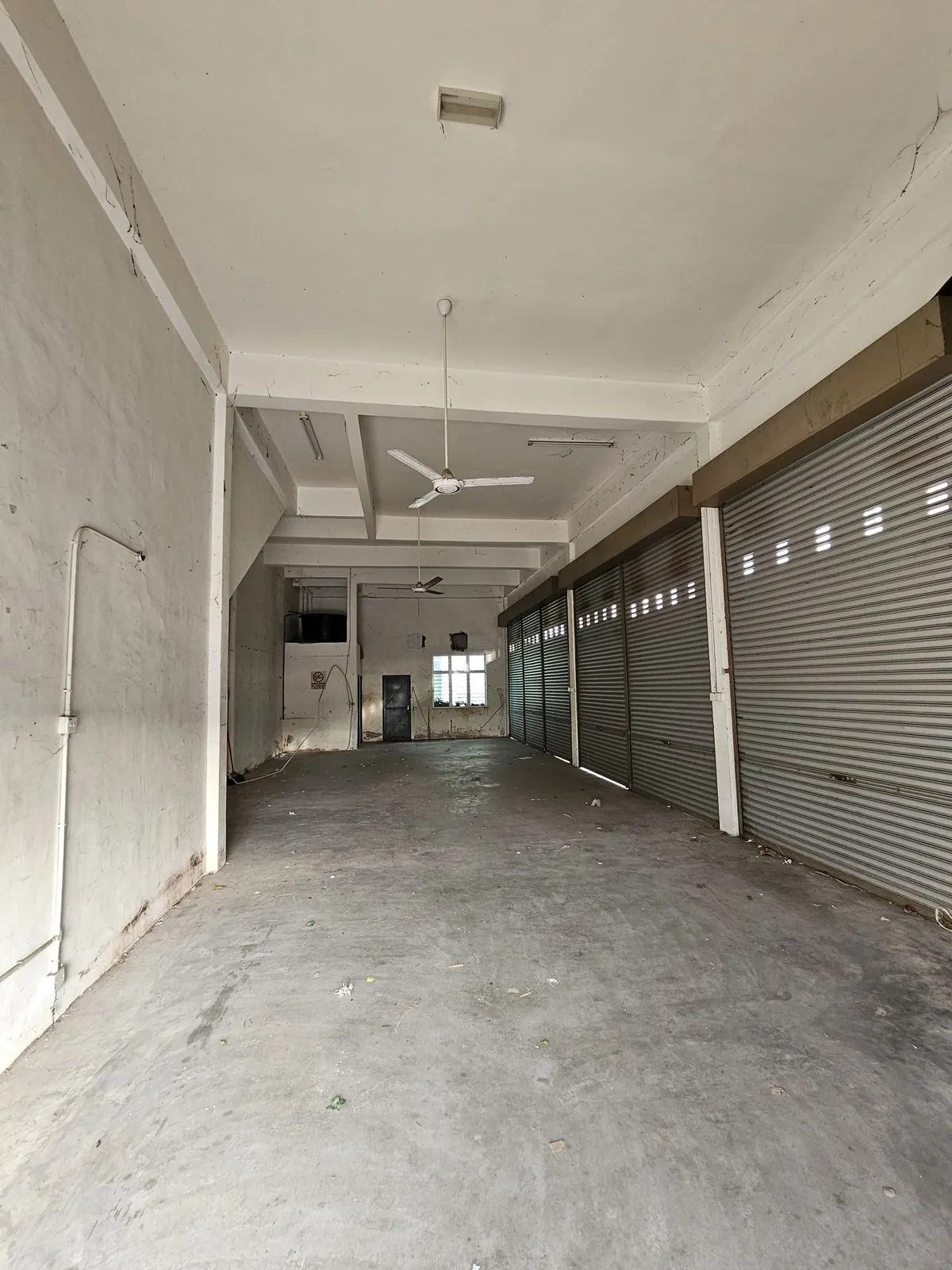 Madam Yeo Hair Care 毛坯长形店内，卷闸门和水泥地