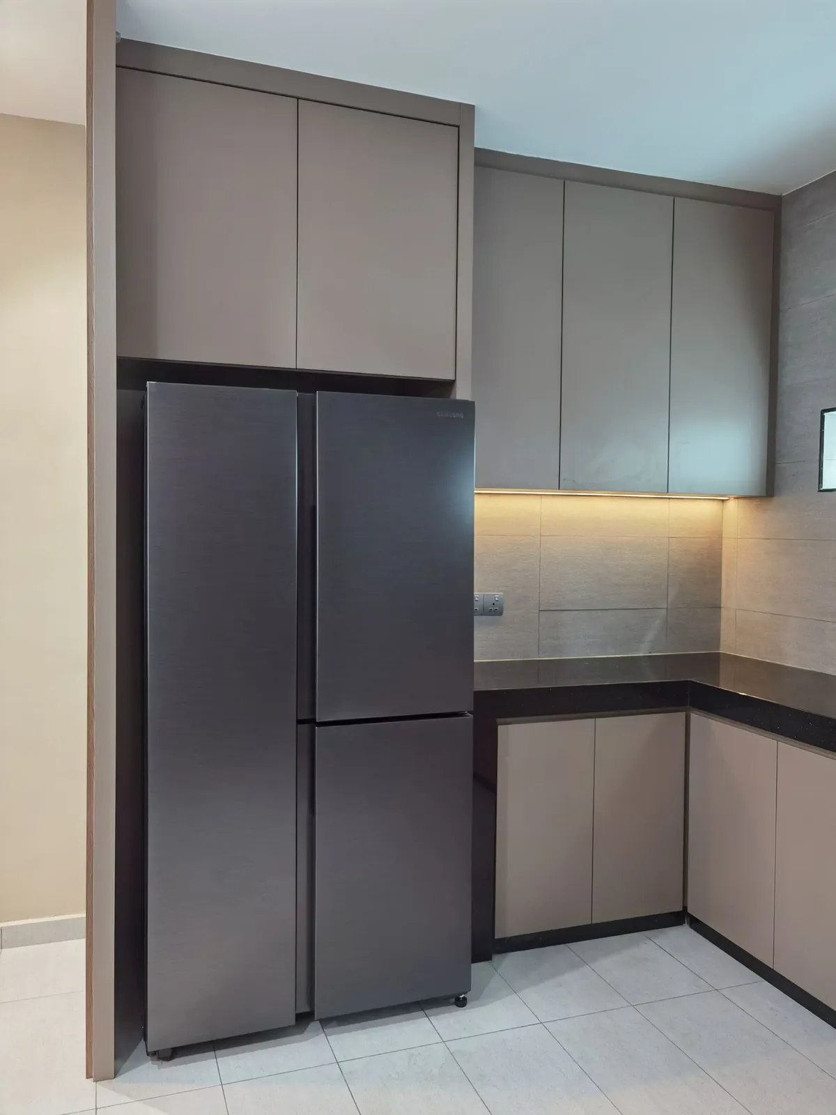 Kitchen cabinets with fridge bay and under-cabinet lighting at Taman Ara Permai