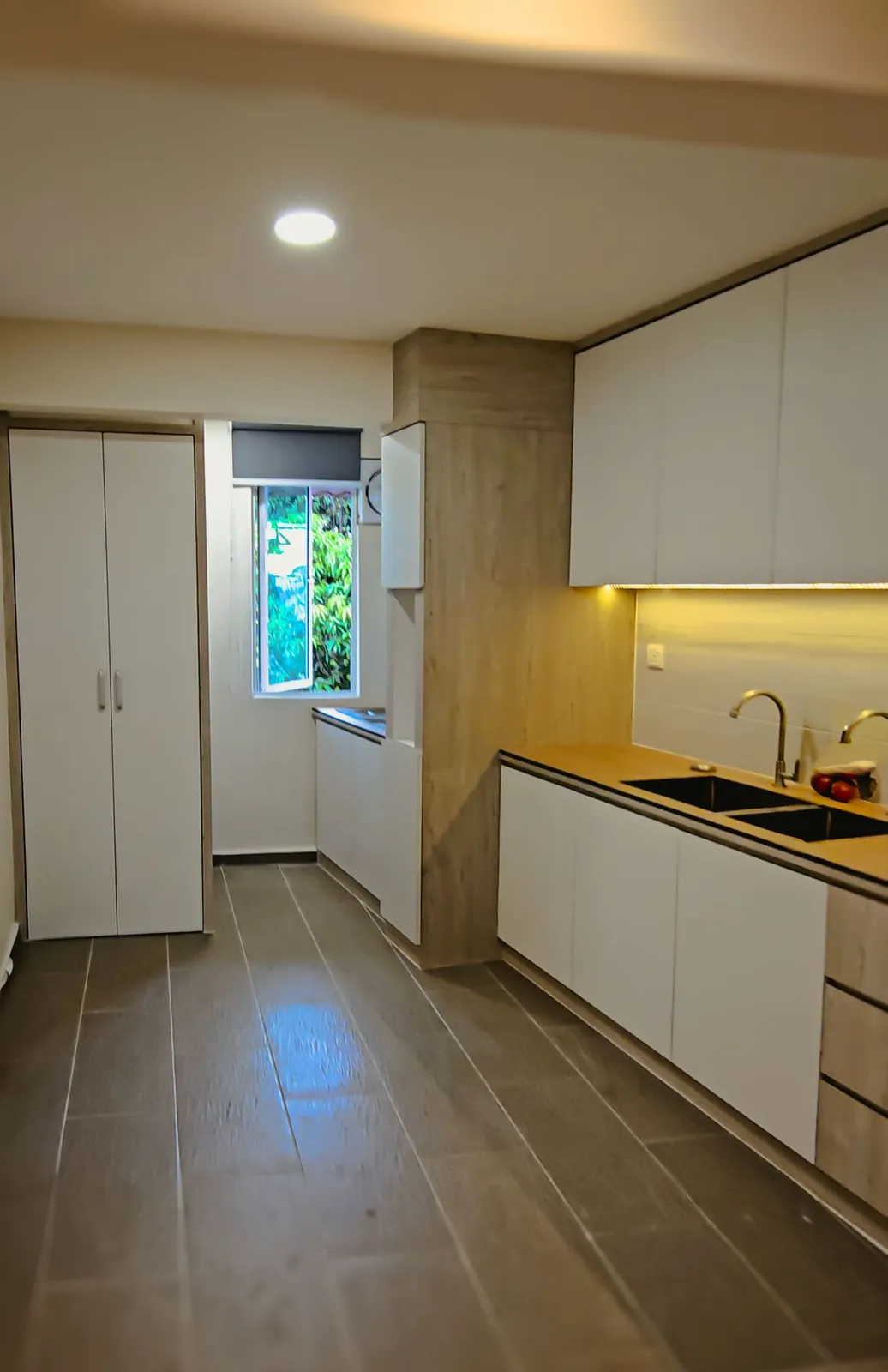 Taman Kesidang galley kitchen with white cabinets and under-cabinet lighting