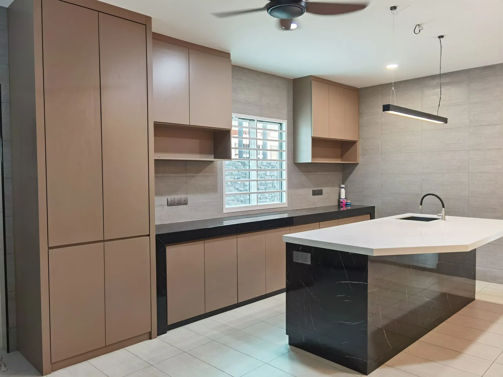 Wet kitchen in a house extension with island and wood-grain cabinets at Taman Ara Permai