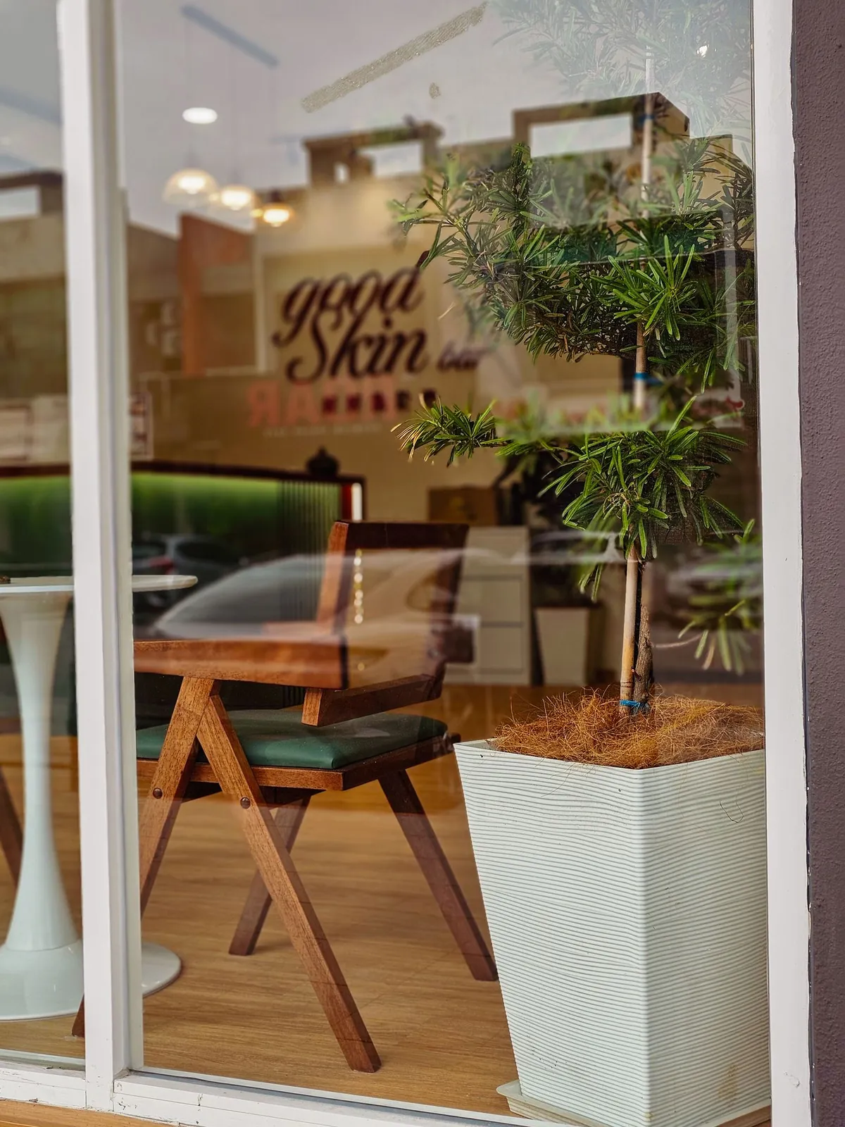 Good Skin Bar shop window with rattan chair and potted tree