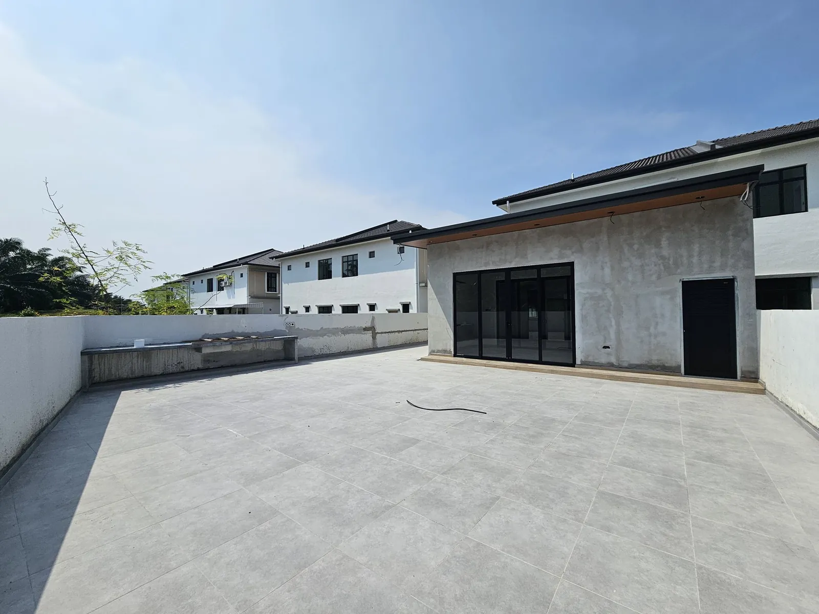 Jasin Parkland rear extension with black-framed sliding doors and a tiled back yard