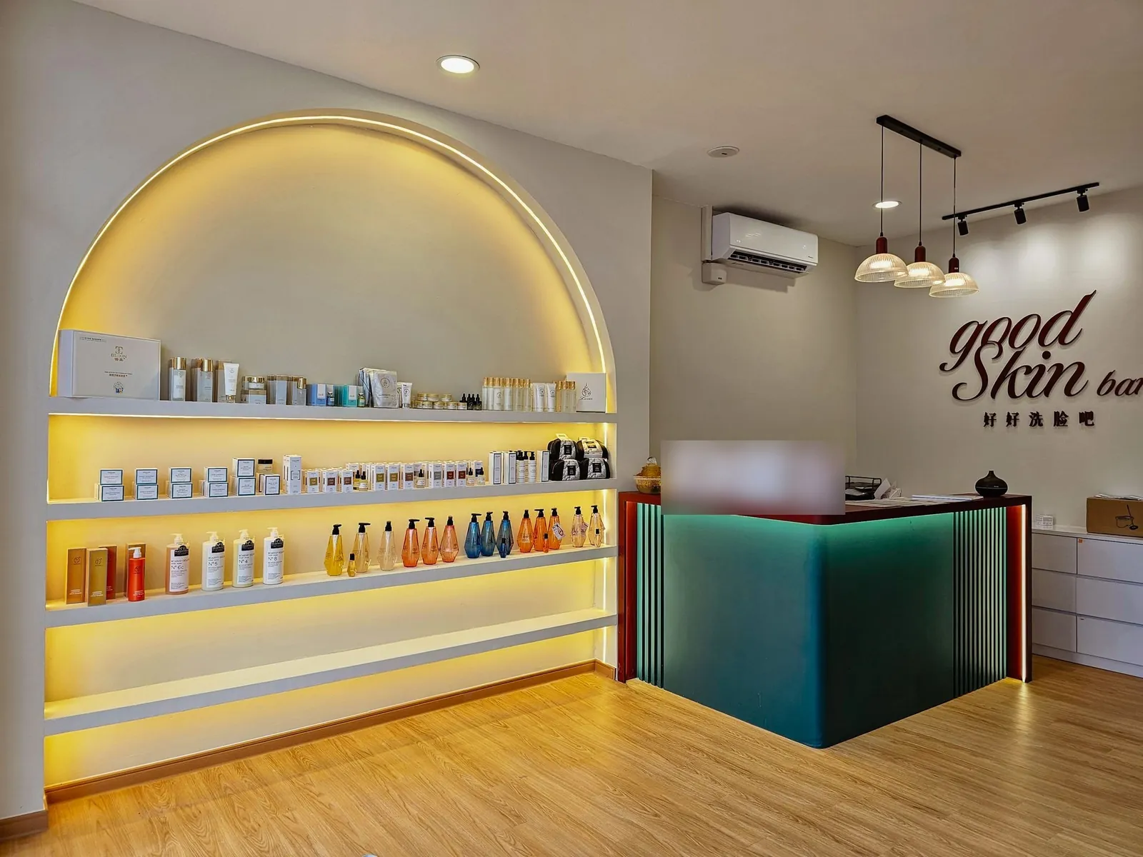 Good Skin Bar renovation: shop with LED-lit arched shelving, teal counter and pendant lights