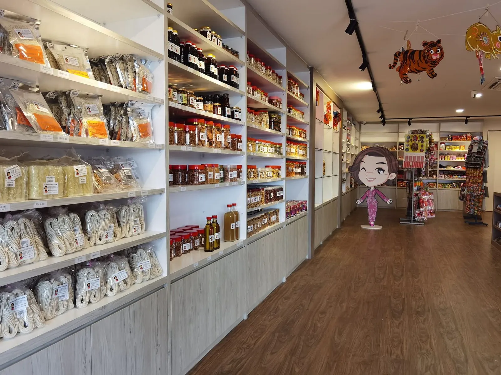 Ah Mok Shop aisle with tall white shelving, track lights and wood-look floor