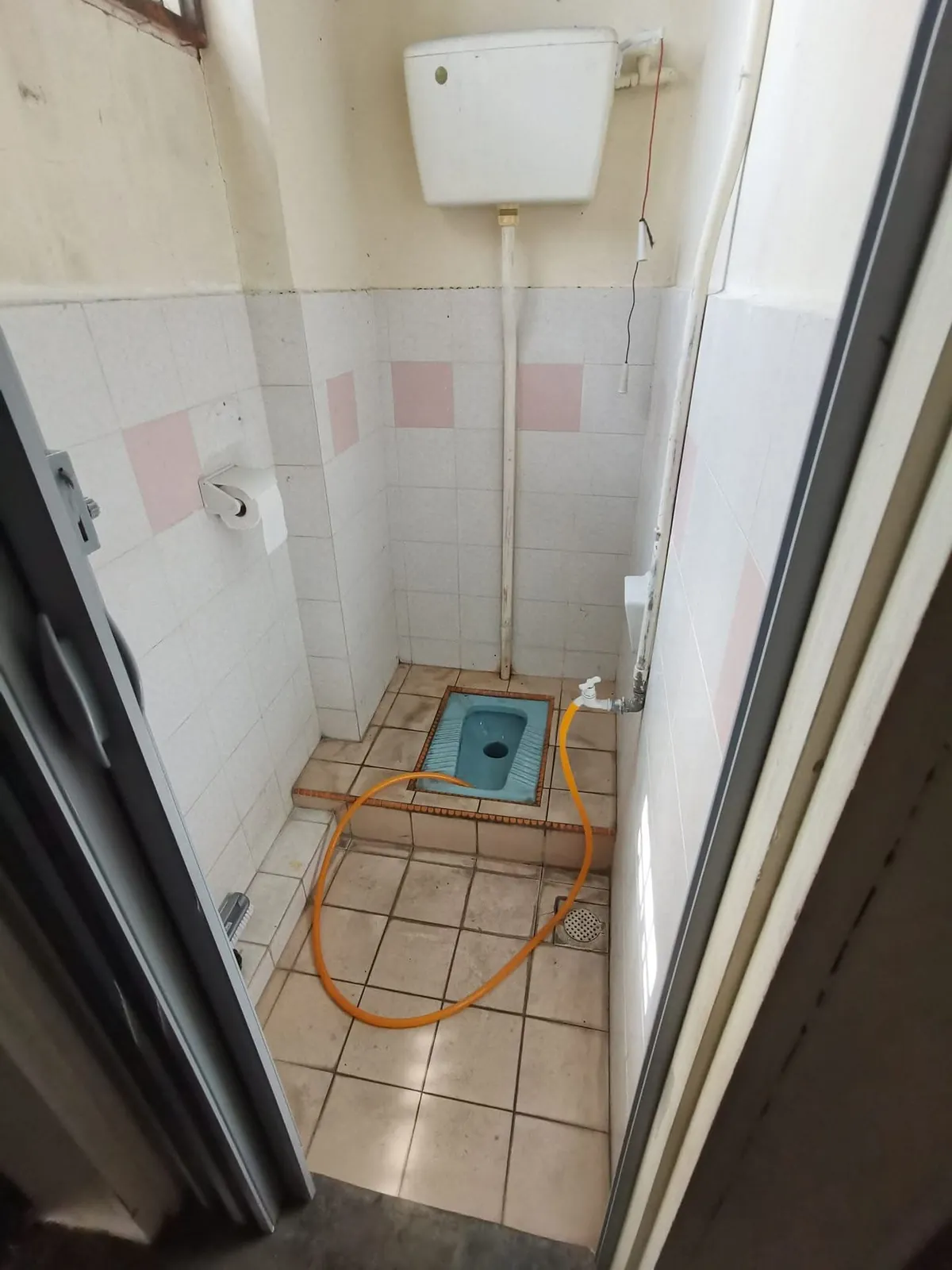 Old Ah Mok Shop toilet with squat pan, high cistern and white tiles
