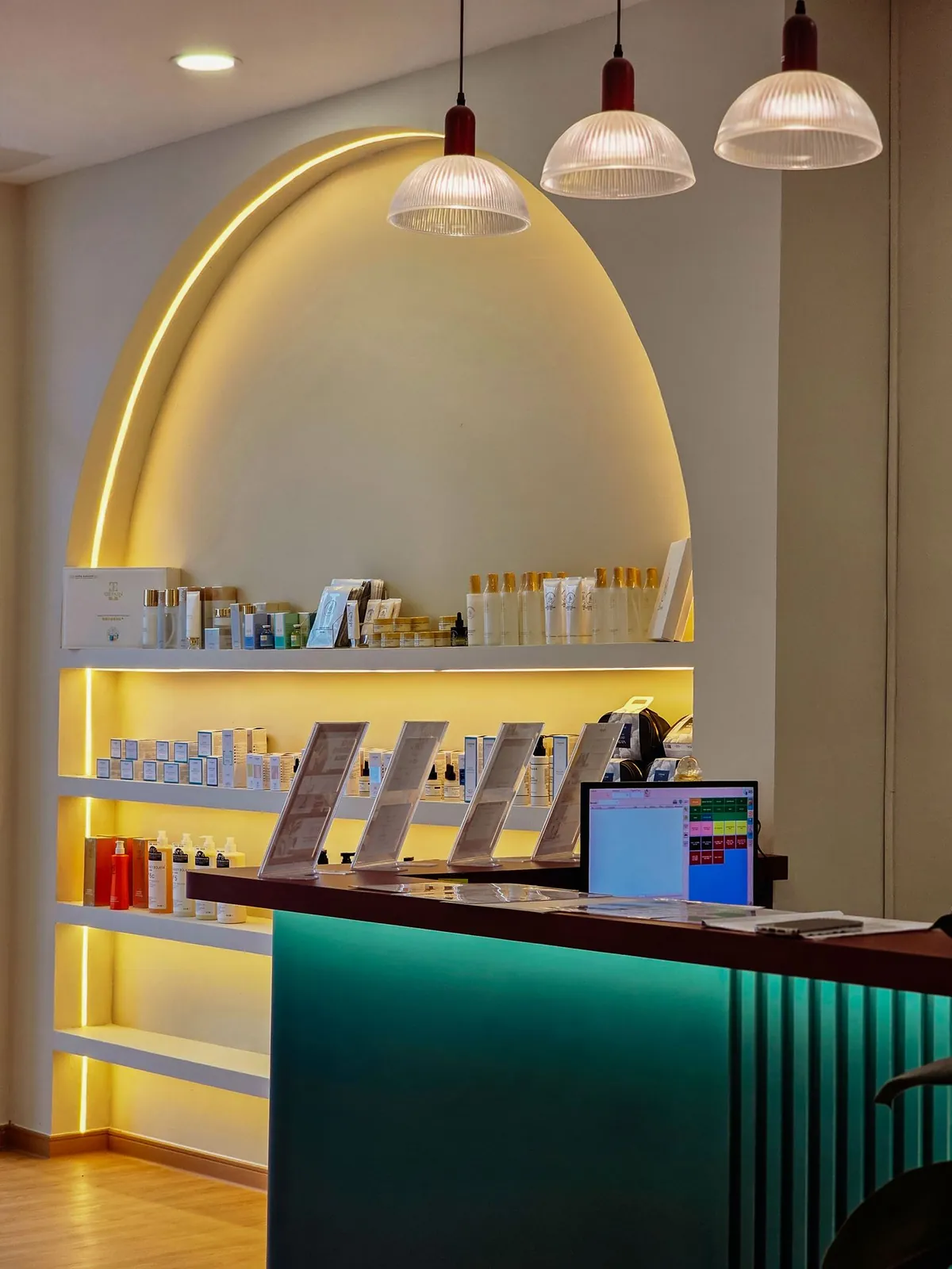 Good Skin Bar LED-lit arched shelving behind the teal counter