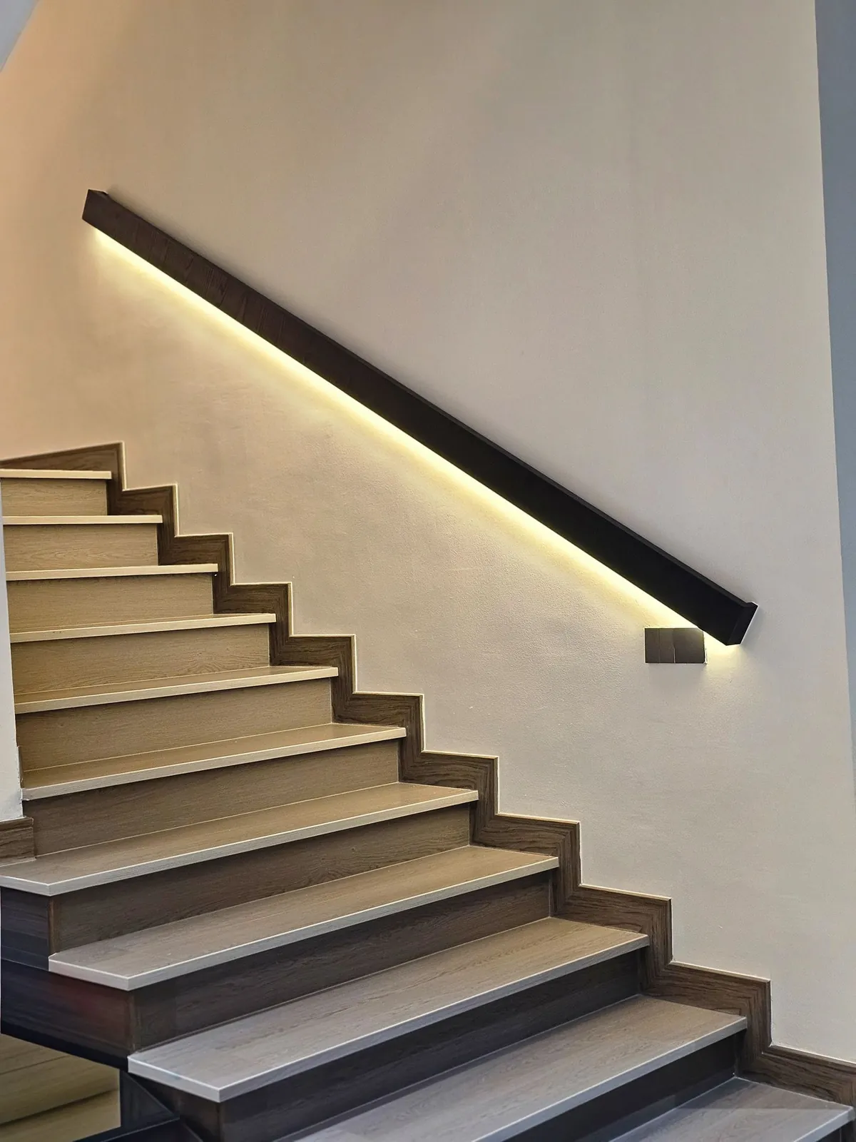 Staircase with grey wood-look treads and a lit floating handrail, Country Villa
