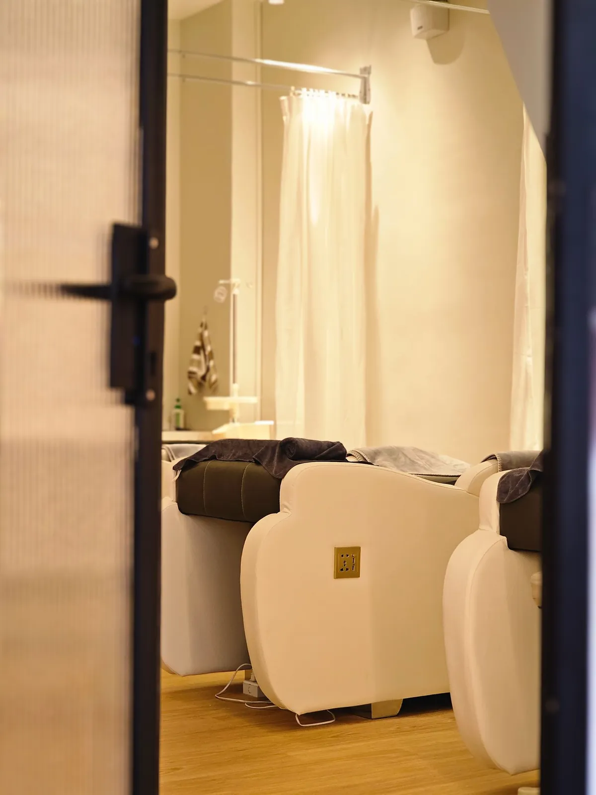 Good Skin Bar treatment room with white facial beds and curtain