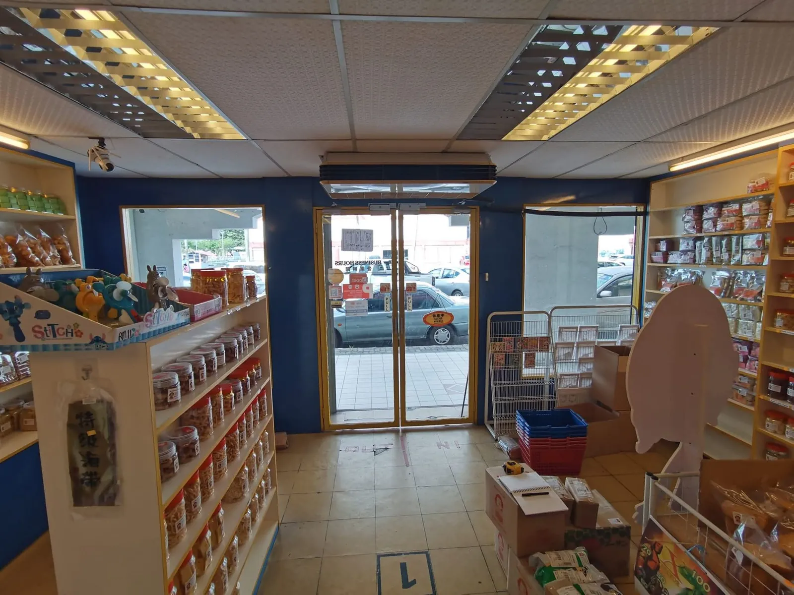 Old Ah Mok Shop interior with grid ceiling, wooden shelving and boxes on floor