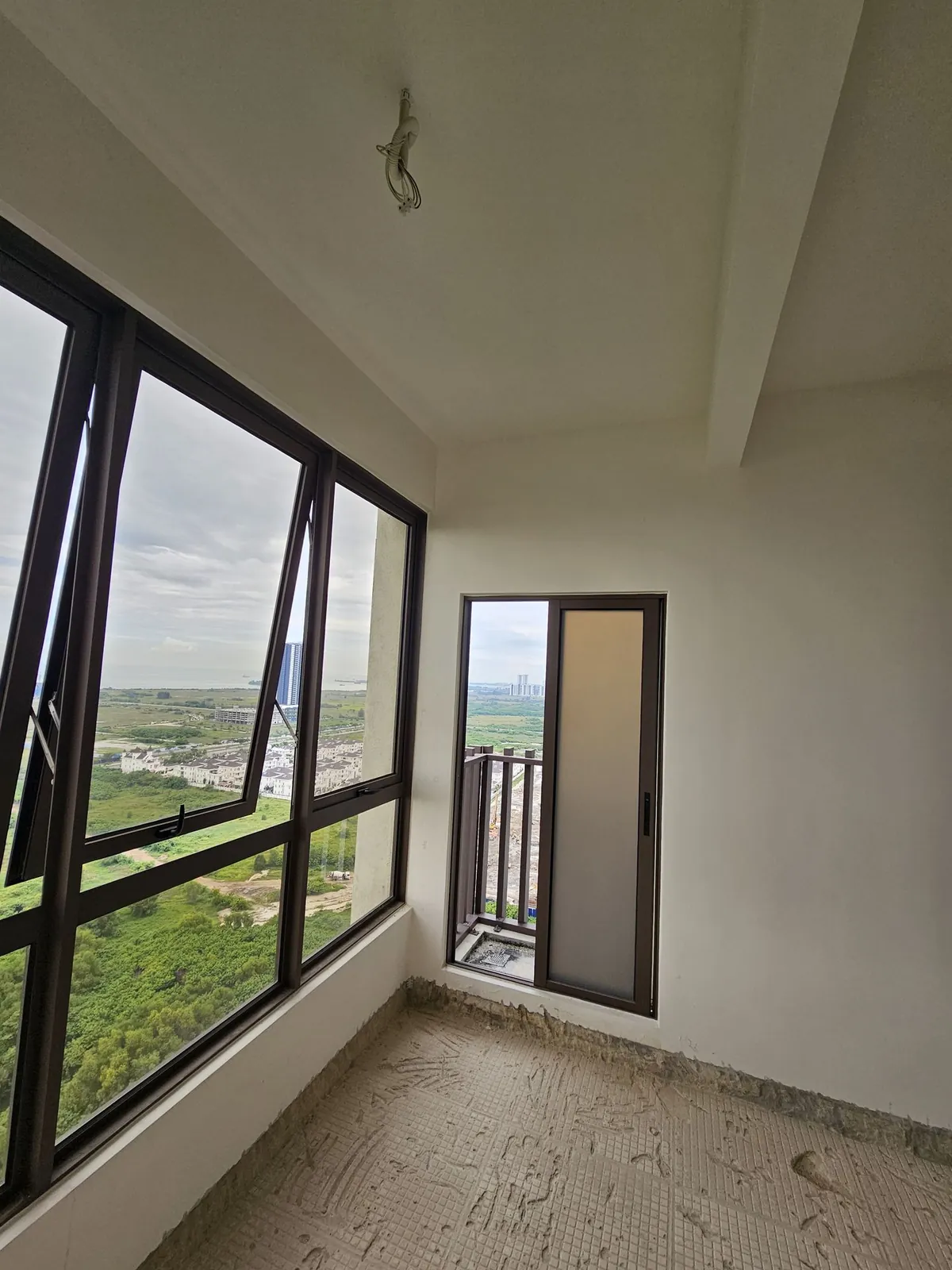 Bali Residence bedroom before work, black-framed windows and bare screed floor