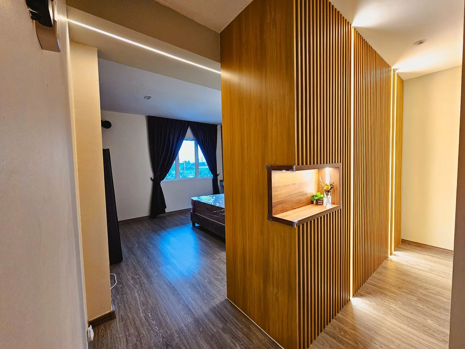 Taman Kesidang slatted timber partition with lit niche leading to bedroom