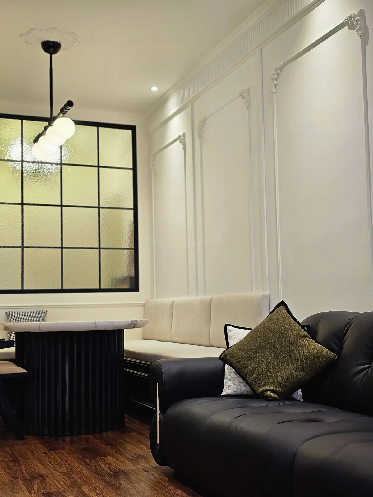 Bali Residence banquette and sofa beside a black-framed textured glass partition