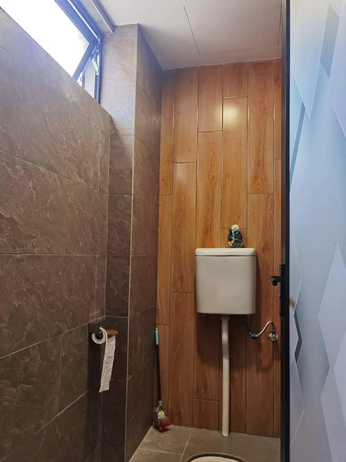 Retiled Ah Mok Shop toilet with wood-look and dark stone-look wall tiles