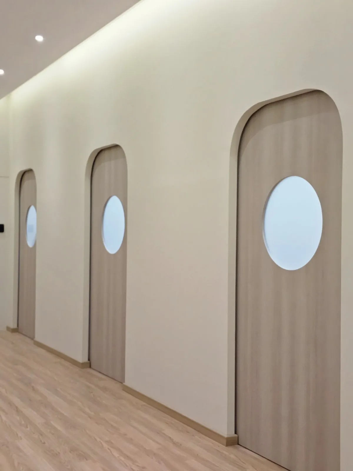 Three arched timber doors with round porthole windows at Kimvets Krubong