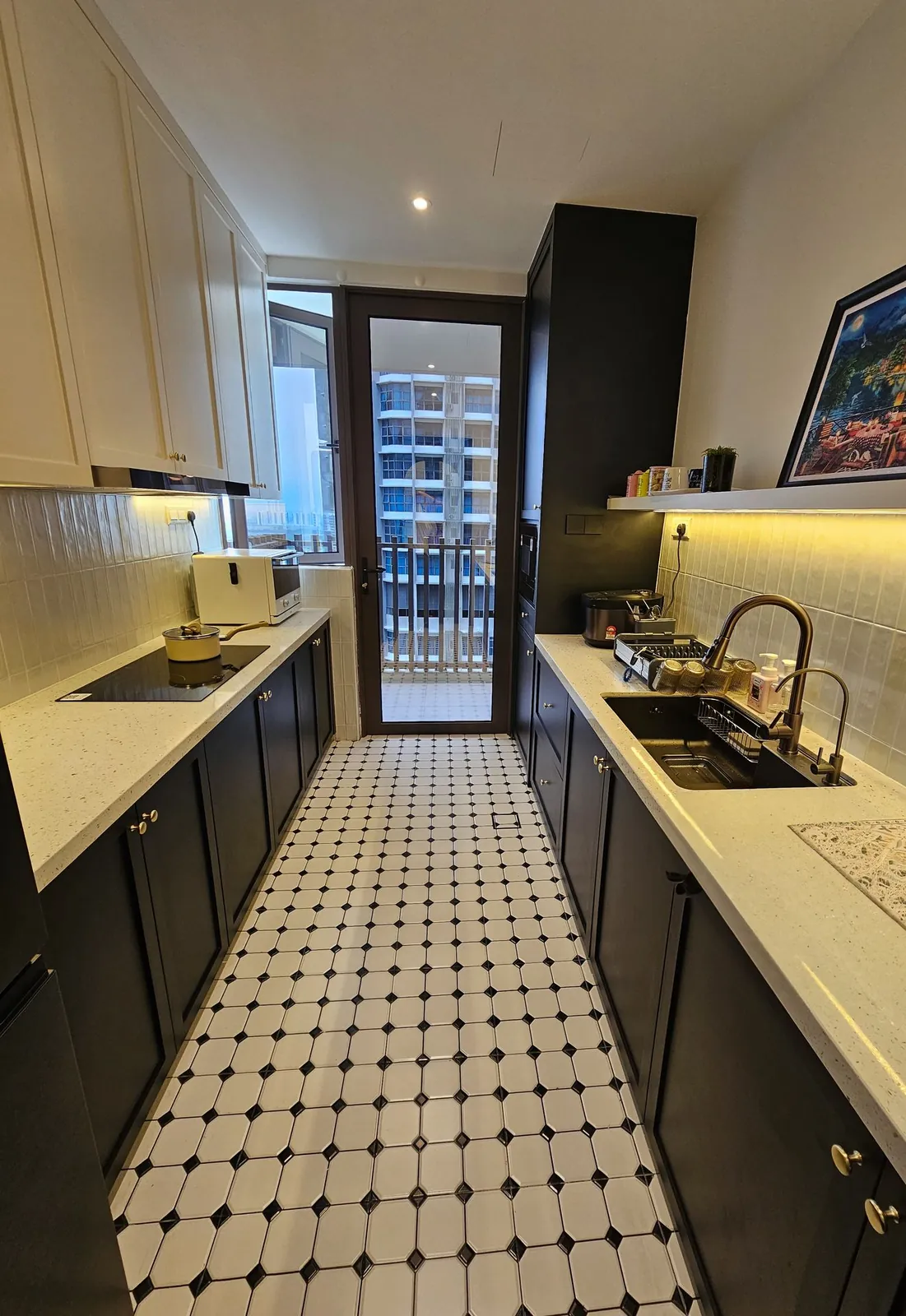 Bali Residence galley kitchen after, black and white cabinets and octagon floor tiles