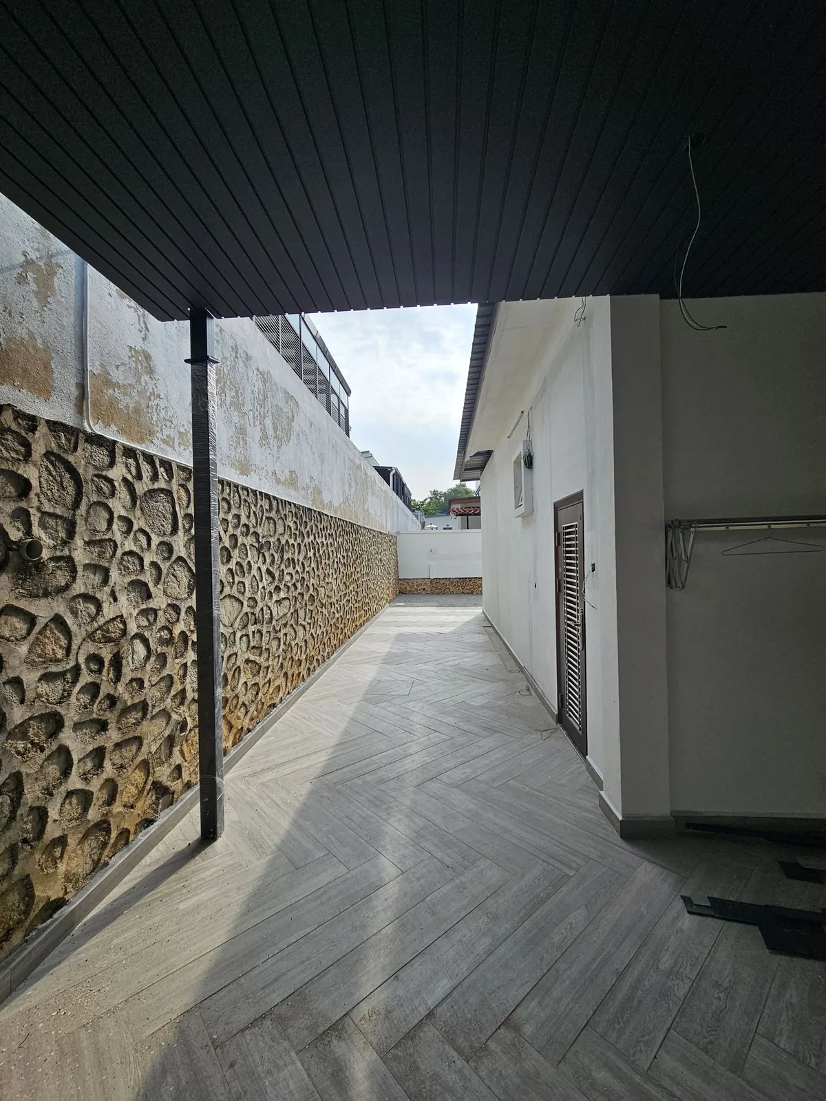 同一条 Belia Antarabangsa 侧边走道，已装遮阳篷、铺木纹砖