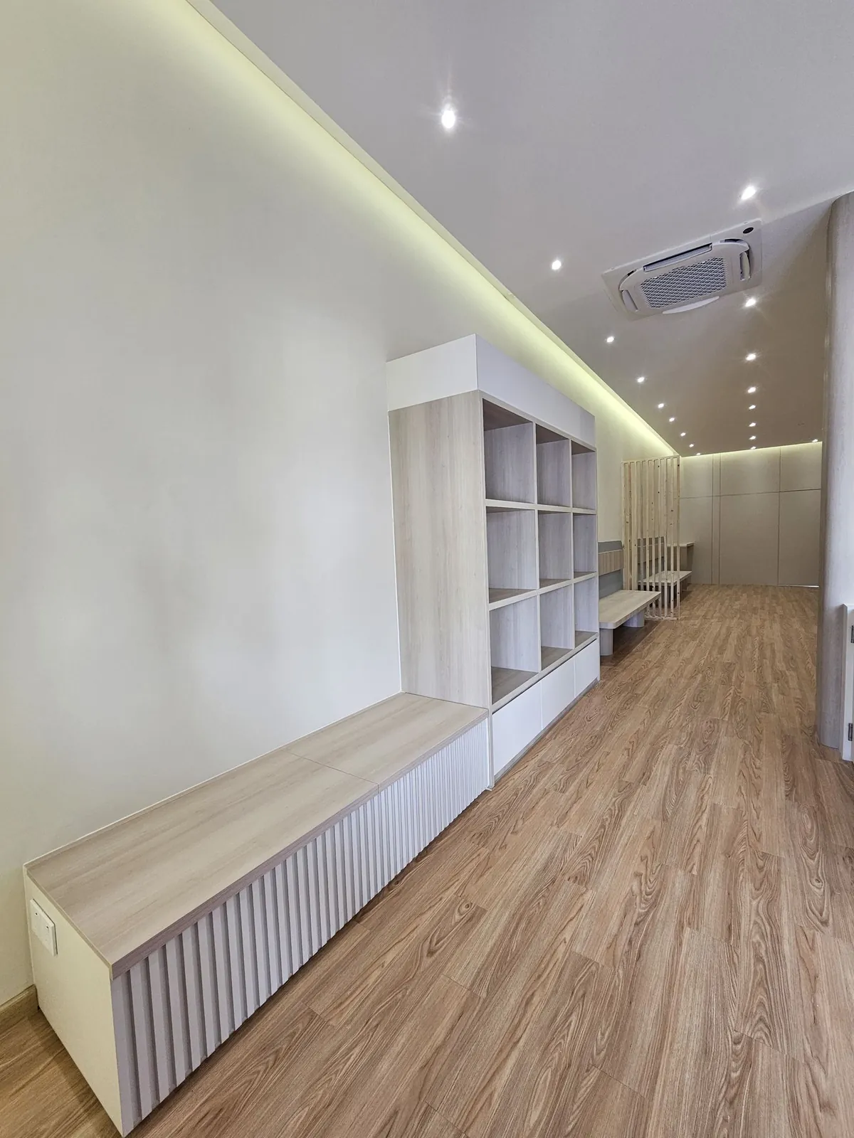 Kimvets Krubong waiting area with slatted bench, shelving and cove-lit ceiling