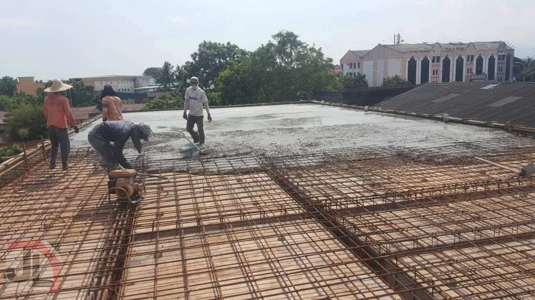 Bachang Temple Office Building workers pouring concrete over the roof slab reinforcement