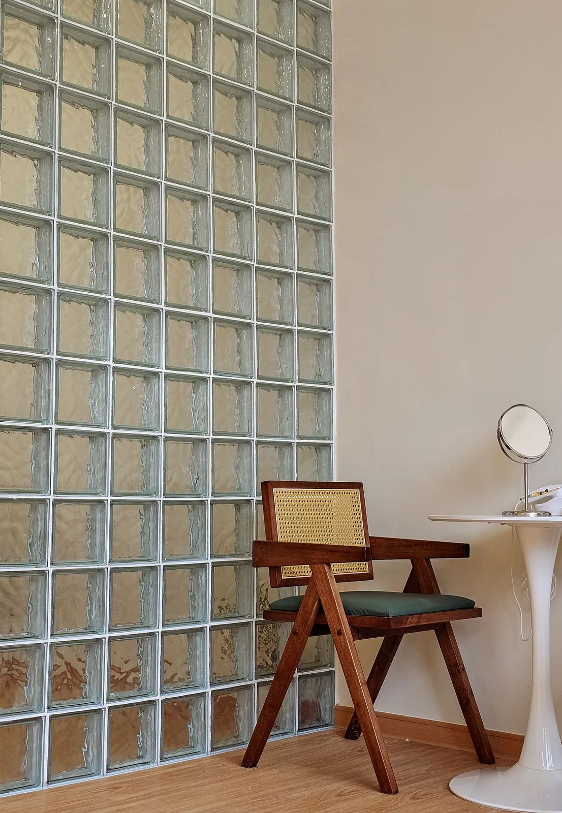 Good Skin Bar rattan chair and side table beside the glass-block wall