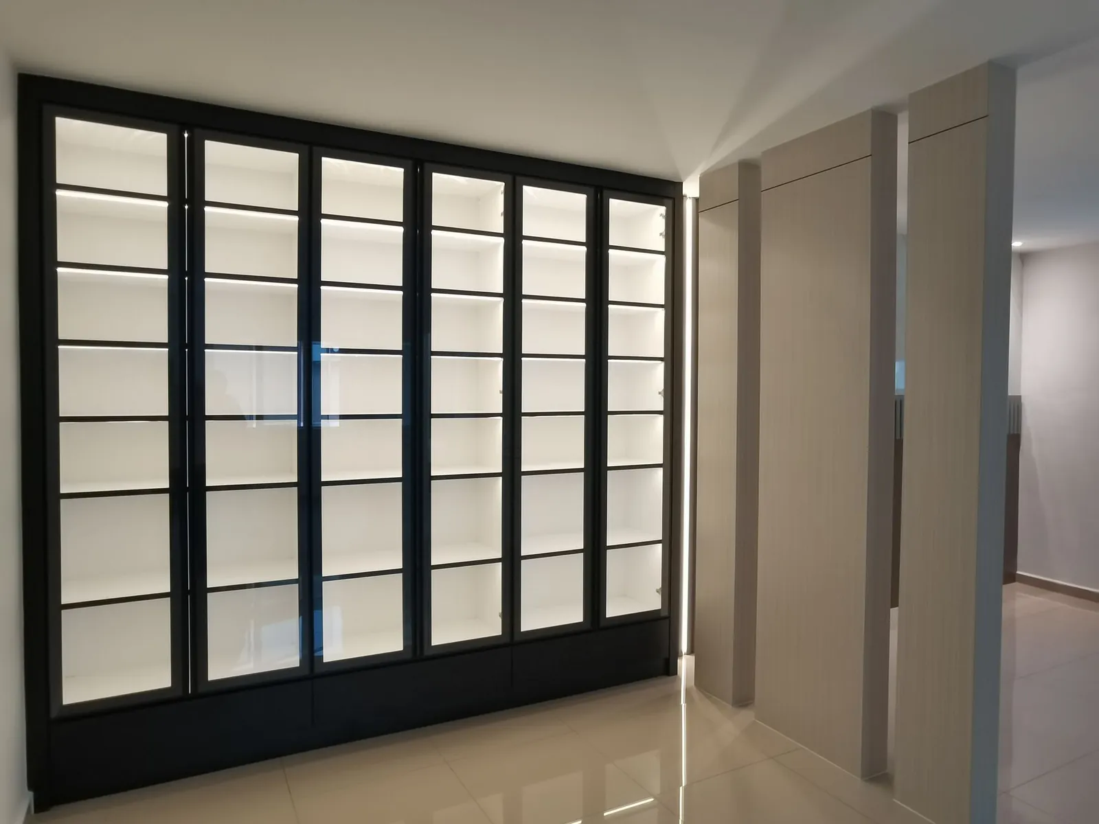 Lit glass display cabinets and wood-grain panels, Melaka carpentry by JL Design & Build at Taman Ara Permai