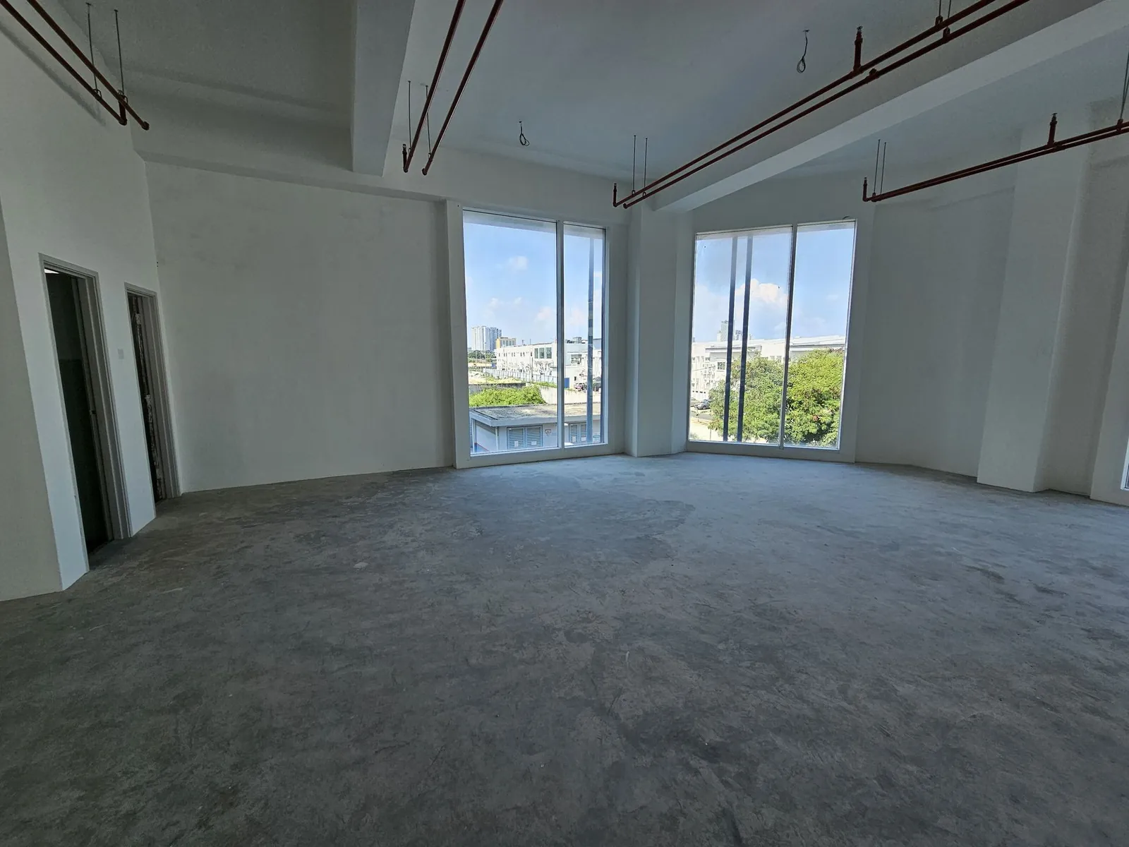 Ee Pilate Studio 装修前的空房间，尽头有两扇落地窗