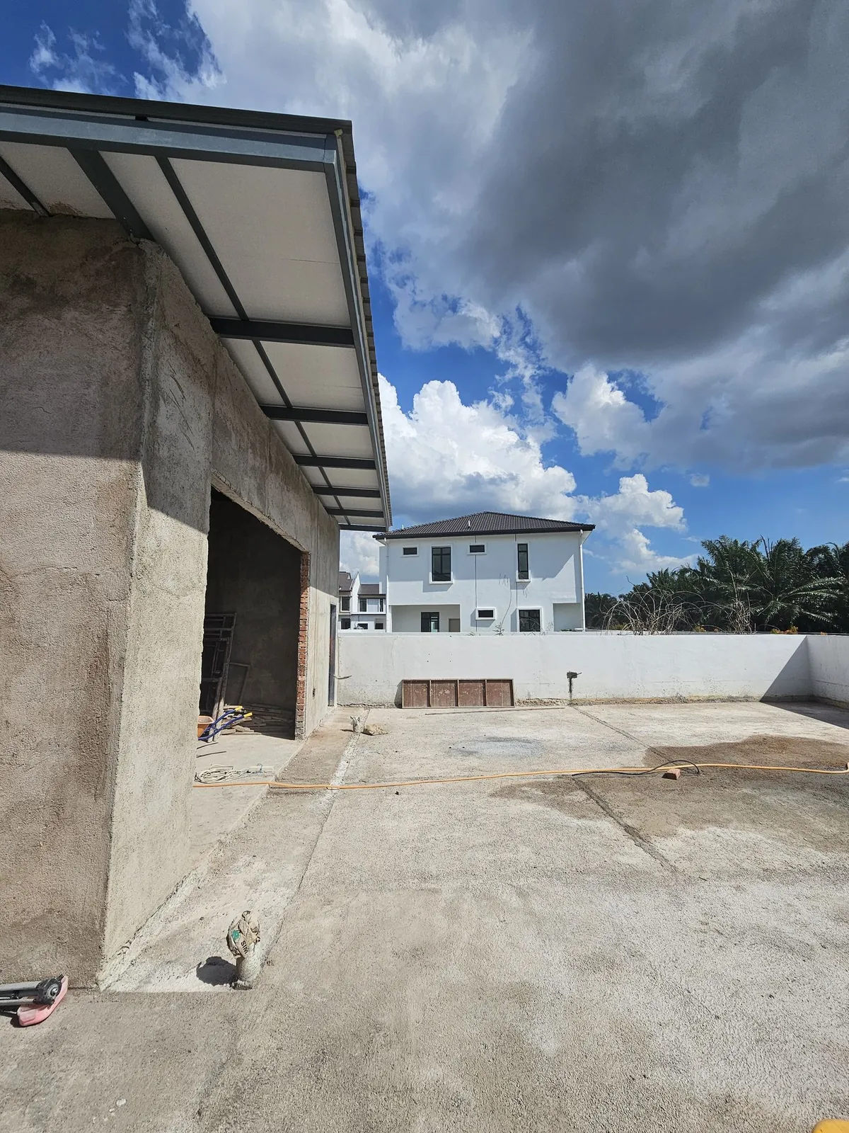 Jasin Parkland roofed extension shell with plastered walls and a concrete yard